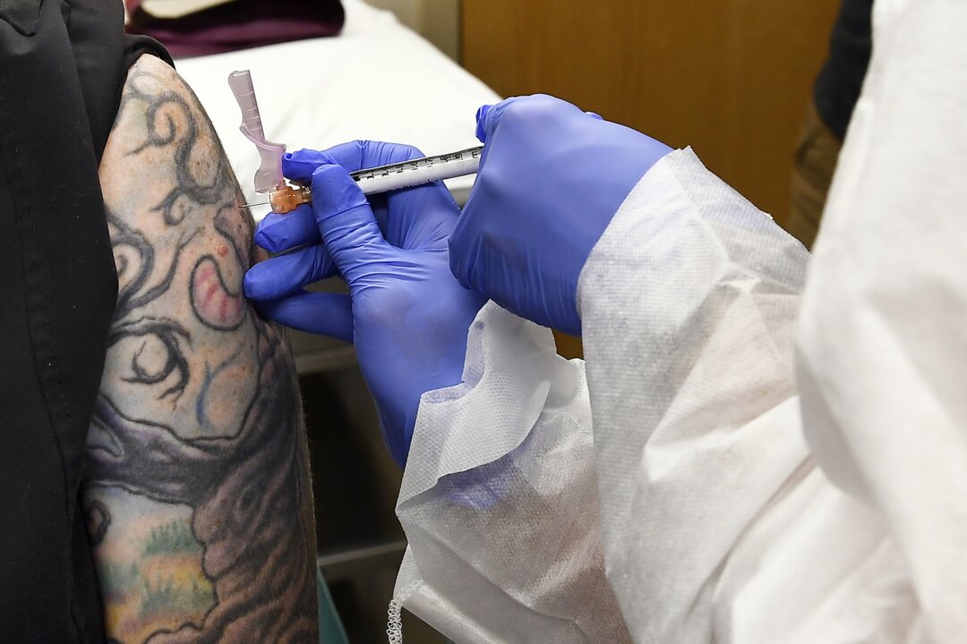 Nurse Kathe Olmstead gives a volunteer an injection as a study of a possible COVID-19 vaccine, developed by the National Institutes of Health and Moderna Inc., gets underway in Binghamton, N.Y., on July 27, 2020. (Hans Pennink/AP Photo)