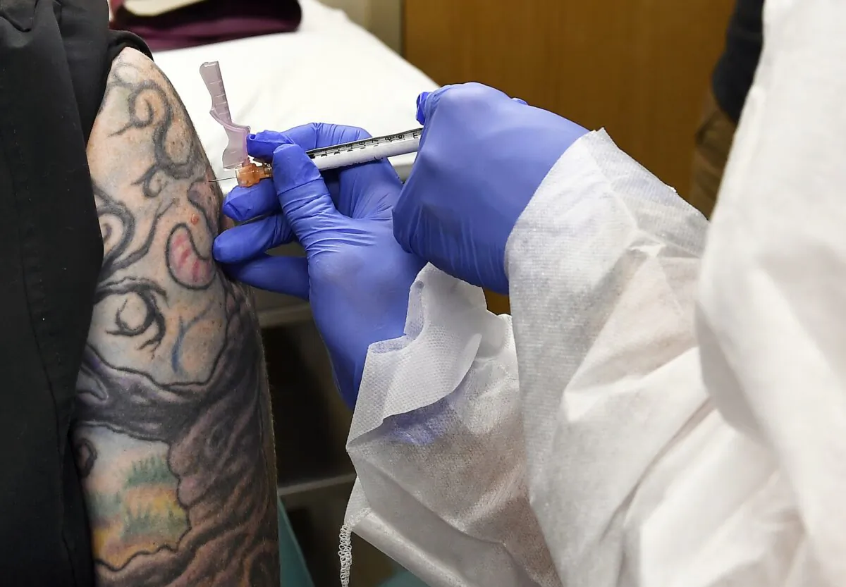 Nurse Kathe Olmstead gives a volunteer an injection as a study of a possible COVID-19 vaccine, developed by the National Institutes of Health and Moderna Inc., gets underway in Binghamton, N.Y., on July 27, 2020. (Hans Pennink/AP Photo)