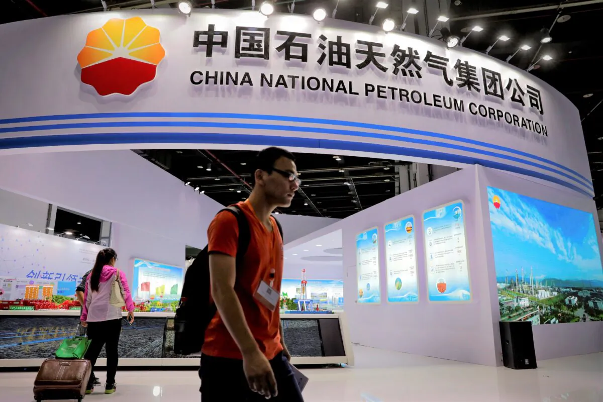 Visitors walk by the China National Petroleum Corporation (CNPC) booth during the China International Chemical Industry Fair in Shanghai, China, on Sept. 21, 2016. (AP Photo/Andy Wong)