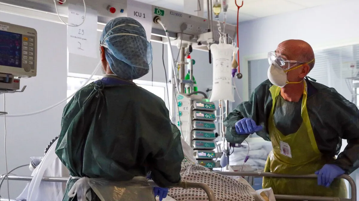 Medical staff wearing full PPE (personal protective equipment) treat a patient with the CCP virus on an Intensive Care Unit at Frimley Park Hospital in Frimley, southwest England, on May 22, 2020. (Steve Parsons/Pool/AFP via Getty Images)