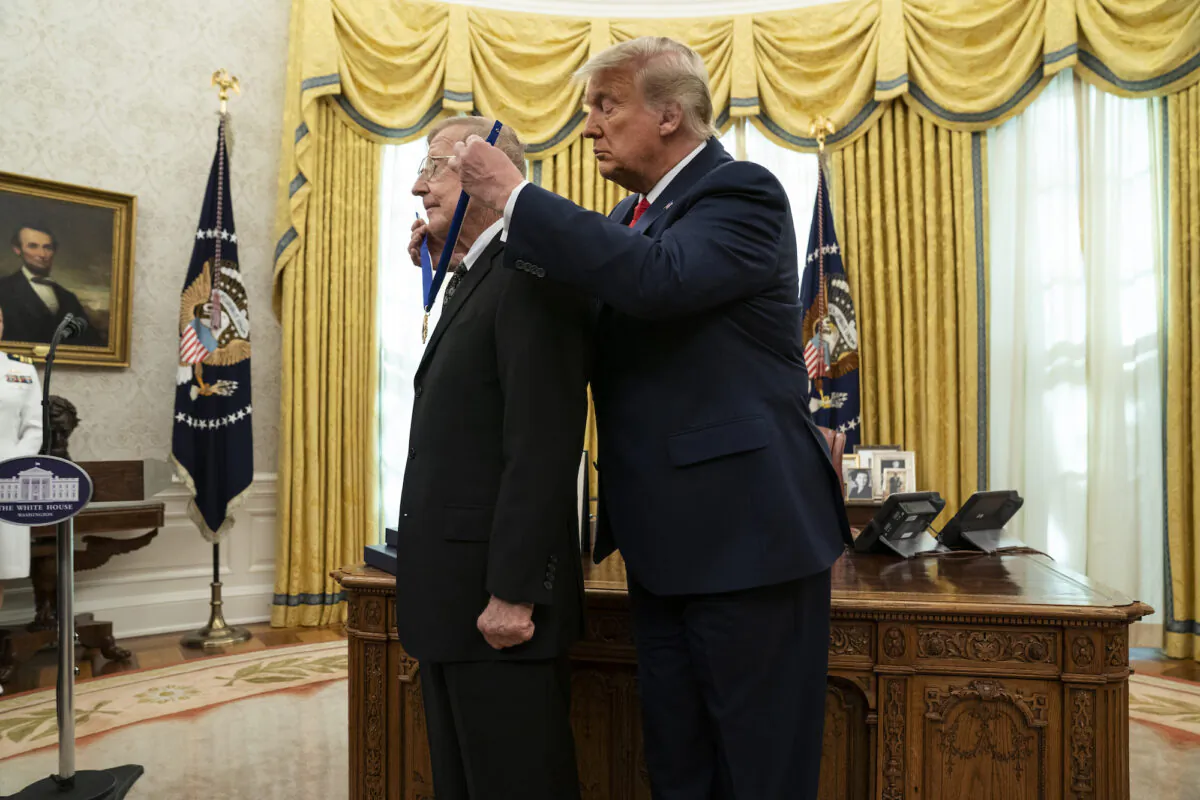 President Donald Trump presents the Presidential Medal of Freedom to former football coach Lou Holtz, in the Oval Office of the White House, in Washington, on Dec. 3, 2020. (AP Photo/Evan Vucci)