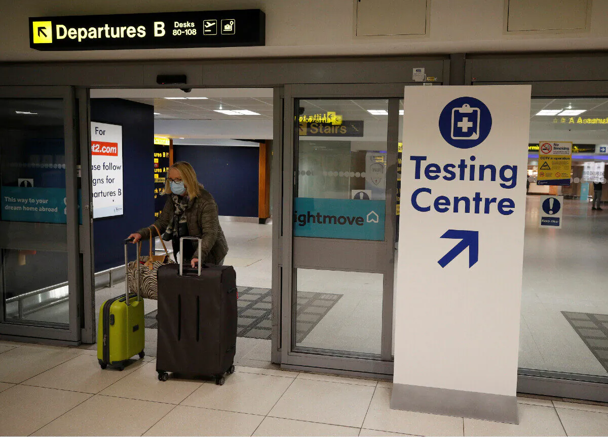 A passenger walks past a testing centre sign in the terminal building of Manchester Airport amid the outbreak of the coronavirus disease in Manchester, UK, on Dec. 3, 2020. (Phil Noble/File Photo/Reuters)