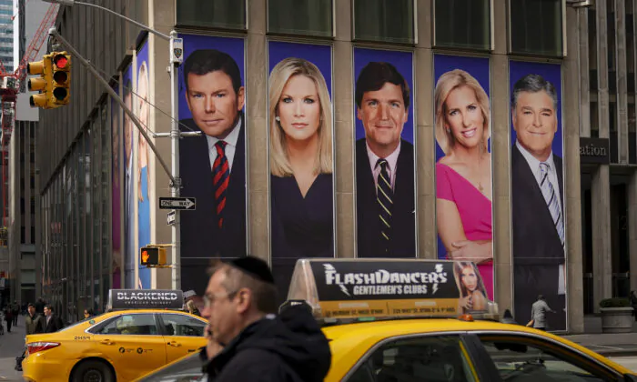 An advertisement features Fox News personalities, including Tucker Carlson and Sean Hannity, in New York, on March 13, 2019. (Drew Angerer/Getty Images)