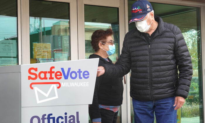 Residents drop mail-in ballots in a ballot box outside of the Tippecanoe branch library in Milwaukee, Wis., on Oct. 20, 2020. (Scott Olson/Getty Images)