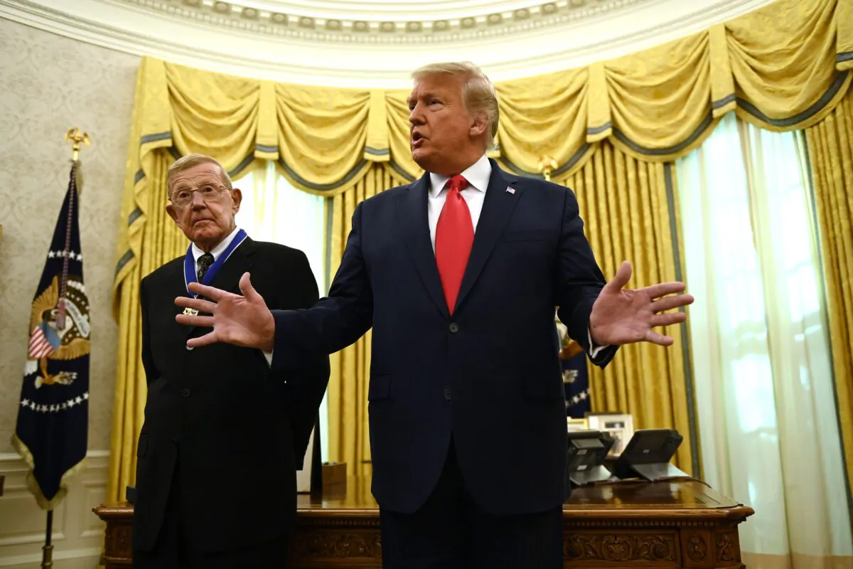 President Donald Trump speaks after awarding the Presidential Medal of Freedom to retired football coach Lou Holtz (L) in the Oval Office of the White House in Washington on Dec. 3, 2020. (Brendan Smialowski/AFP via Getty Images)