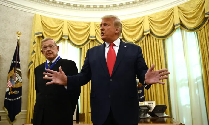 President Donald Trump speaks after awarding the Presidential Medal of Freedom to retired football coach Lou Holtz (L) in the Oval Office of the White House in Washington on Dec. 3, 2020. (Brendan Smialowski/AFP via Getty Images)