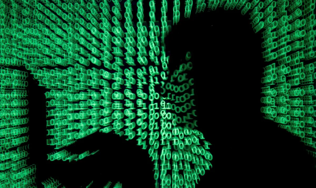 A man holds a laptop computer as cyber code is projected on him in this illustration picture taken on May 13, 2017. (Kacper Pempel/Reuters)