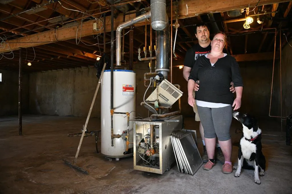 Homeowners Cora and Alec Dion pose in the basement of their home in Fort McMurray, Alta., Canada, on May 8, 2020. (Greg Halinda/The Canadian Press)