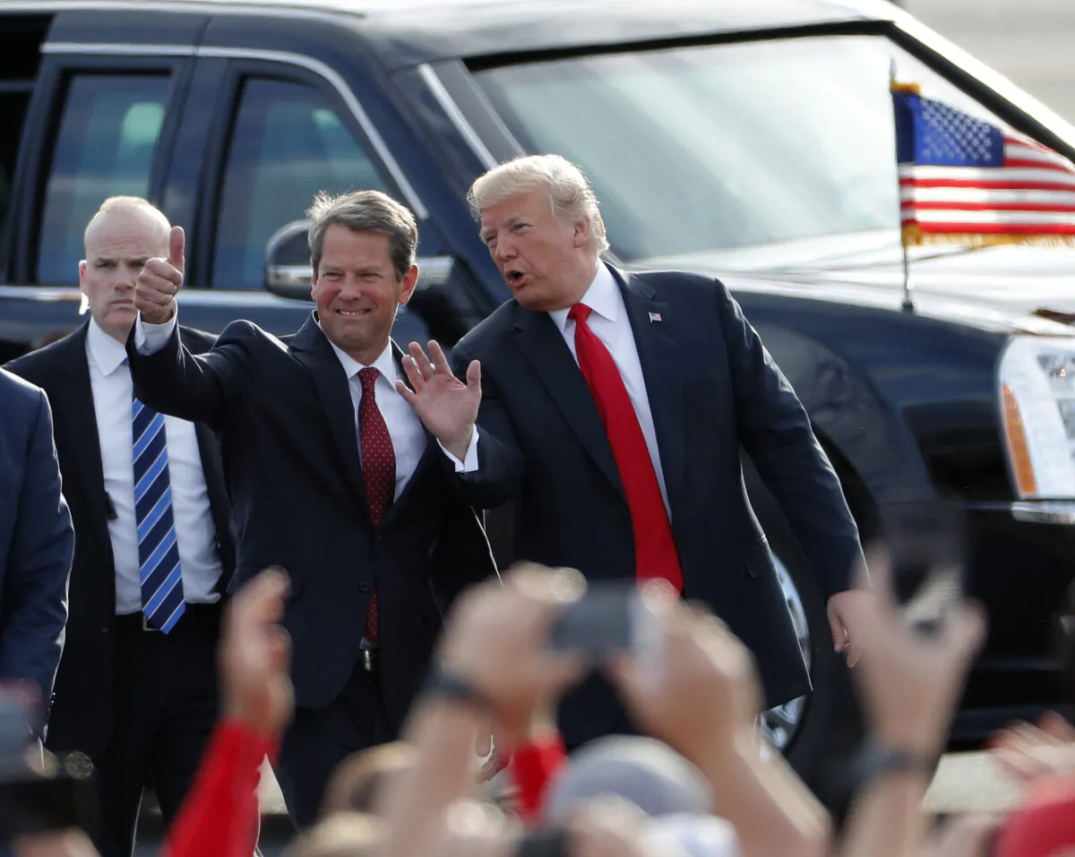 Then-Georgia Republican gubernatorial candidate Brian Kemp, left, walks with then-President Donald Trump as Trump arrives for a rally in Macon, Ga., on Nov. 4, 2018. (John Bazemore/AP Photo)