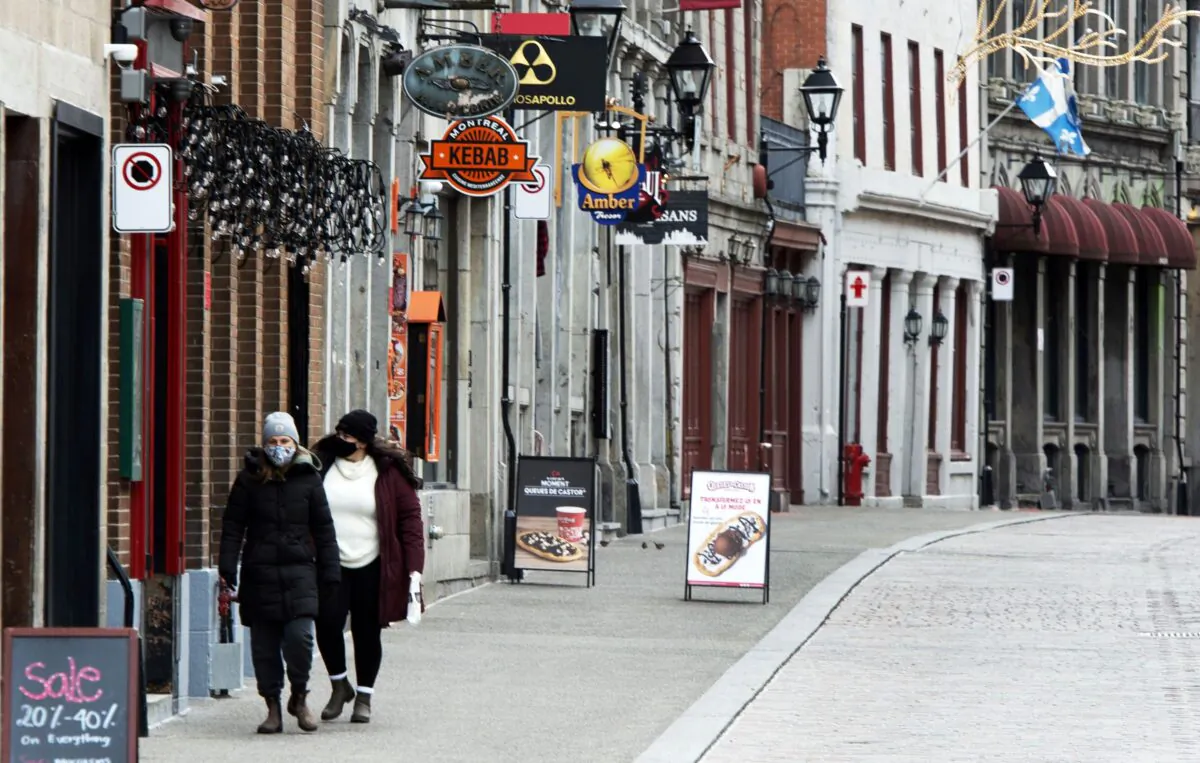 People walk along a deserted street in Old Montreal on Nov. 18, 2020. (The Canadian Press/Ryan Remiorz)