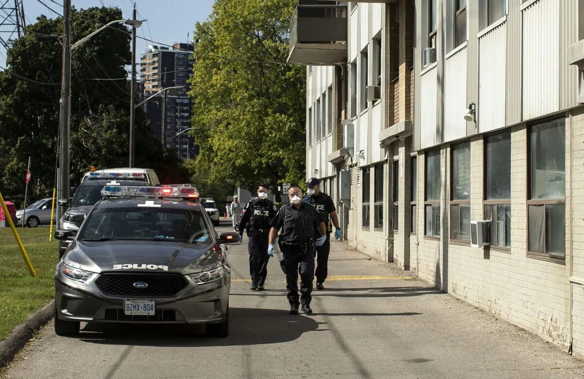 Police officers arrive at a housing development in Toronto to evict a woman who hadn’t paid rent since April, on Sept. 21, 2020, after community activists blocked a sheriff’s attempt to evict her. (The Canadian Press/Chris Young)