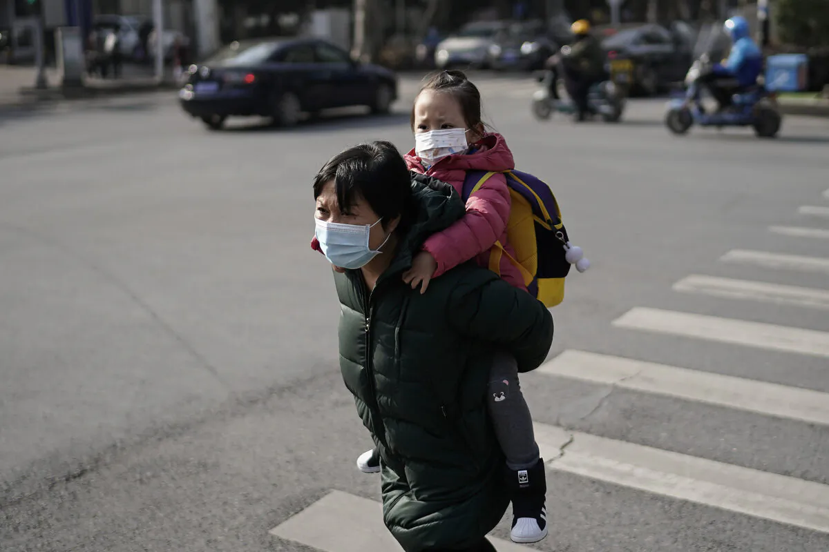 People wearing protective face masks walk along a business street in Wuhan, China, on Dec. 5, 2020. (Getty Images)
