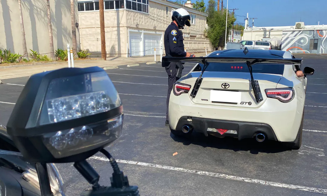 A Newport Beach police officer talks to the driver of a vehicle with loud emissions in Newport Beach, Calif. (Courtesy of the Newport Beach Police Department)