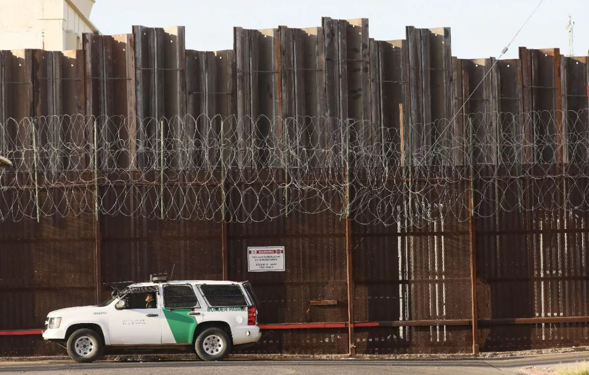 A Border Patrol agent is posted in front of the U.S.-Mexico border barrier in Imperial County on July 24, 2020. (Mario Tama/Getty Images)