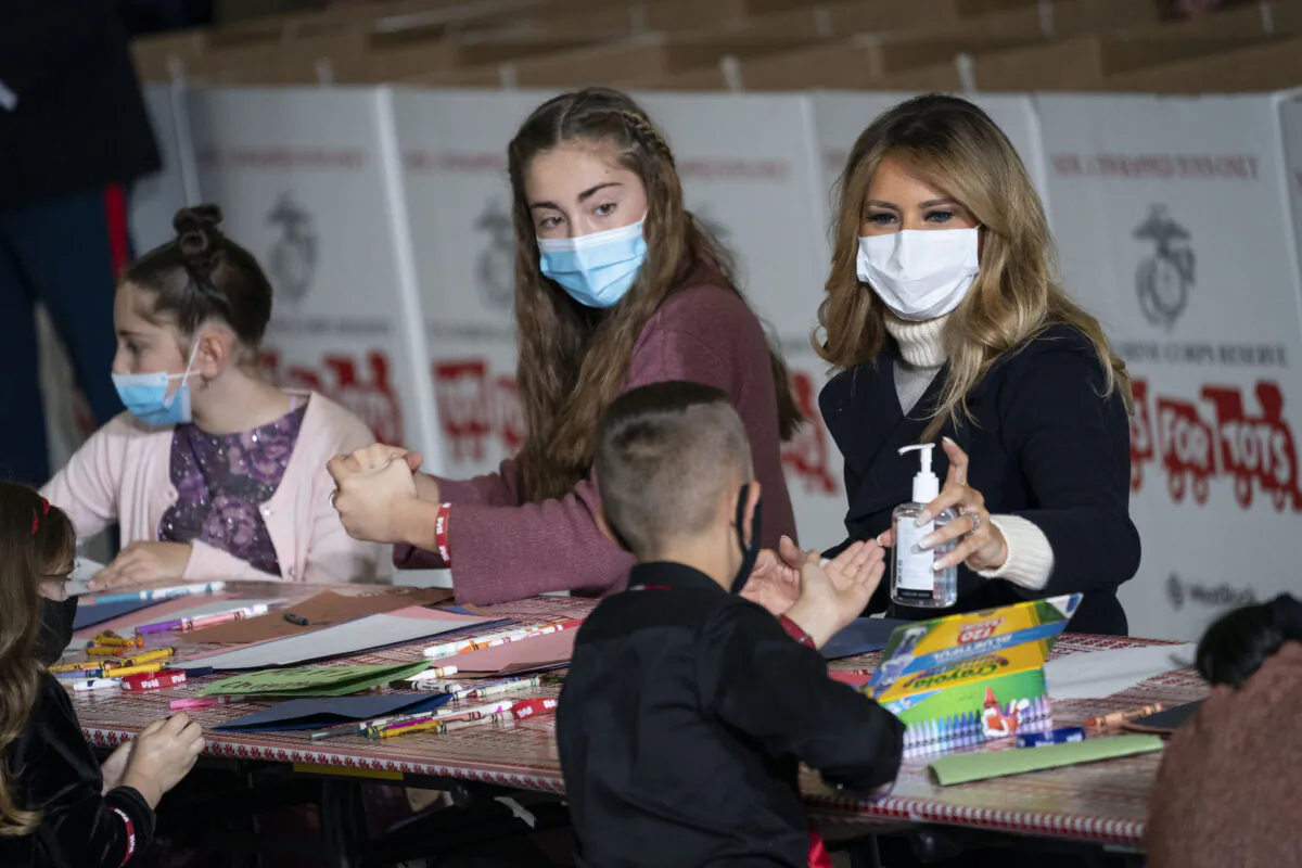 First Lady Melania Trump offers hand sanitizer to a child as they make Christmas cards during the annual Marine Toys for Tots Drive at Joint Base Anacostia-Bolling in Washington on Dec. 8, 2020. (Drew Angerer/Getty Images)