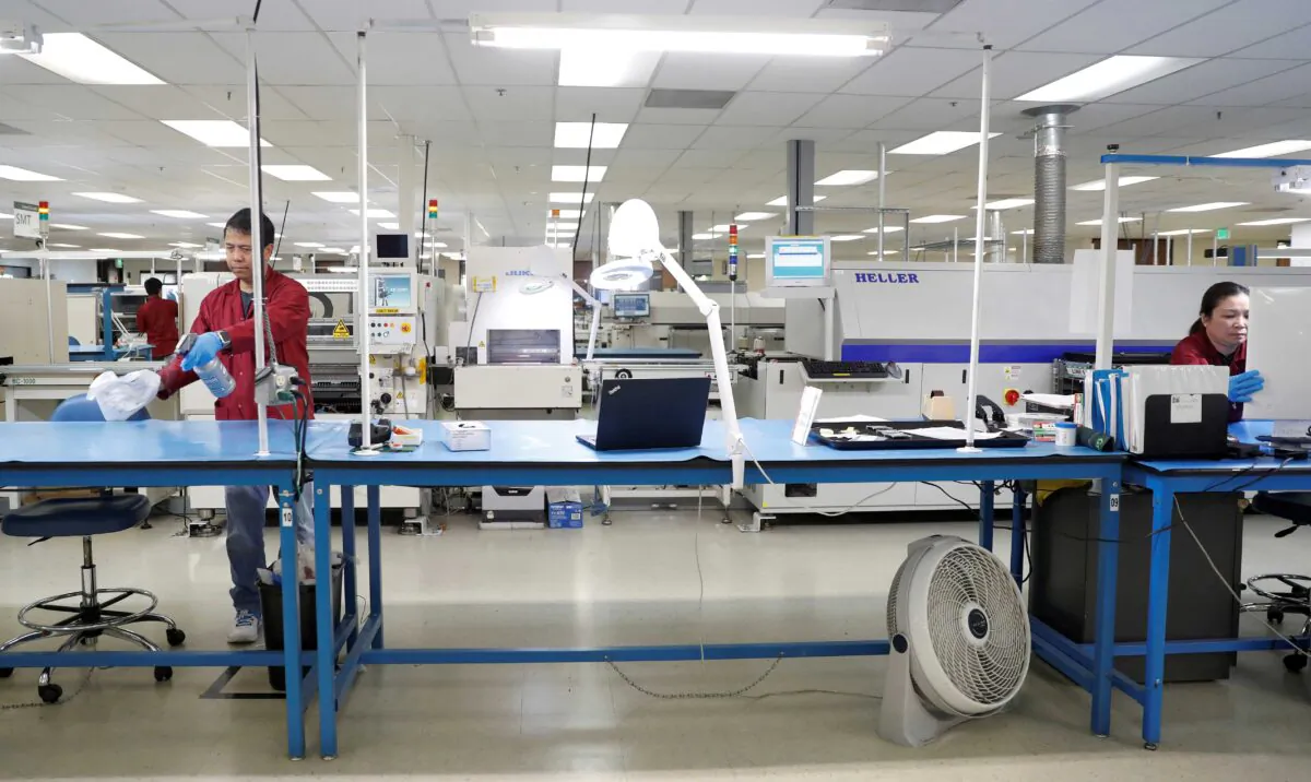 Workers disinfect a production line while maintaining social distancing at the start of a shift at Green Circuits as the company, an essential business, adapts to operating during the outbreak of the fast-spreading coronavirus disease (COVID-19) in San Jose, Calif., on April 2, 2020. (Stephen Lam/Reuters)