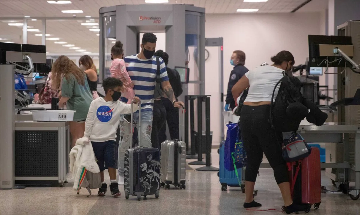 A family wears face masks as they pass security at Terminal A of IAH George Bush Intercontinental Airport amid the coronavirus disease (COVID-19) outbreak in Houston, Texas, on July 21, 2020. (Adrees Latif/Reuters)