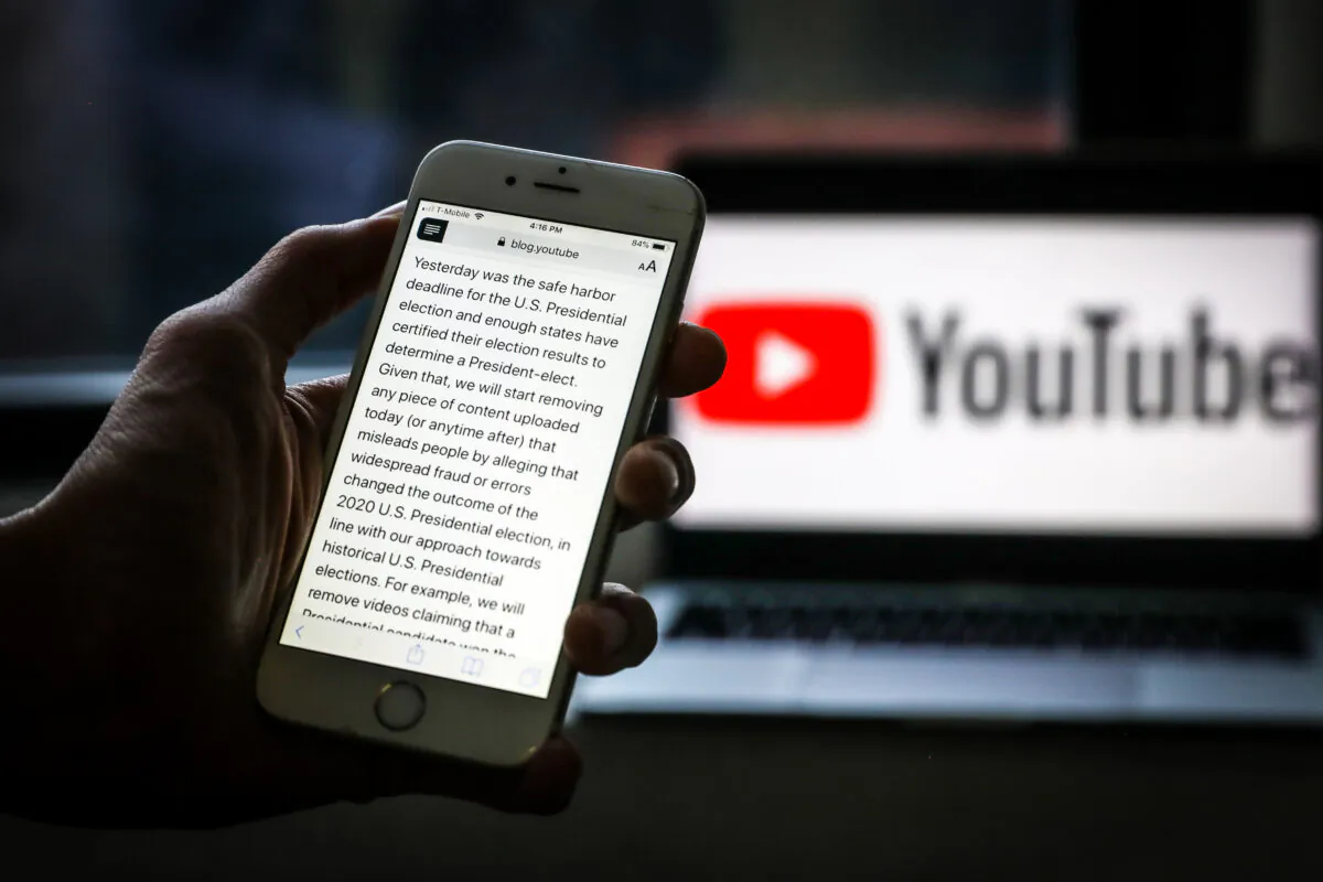 A YouTube announcement that the company will immediately start removing content alleging "widespread fraud or errors" in this year's presidential election, is displayed on a phone on Dec. 9, 2020. (Samira Bouaou/The Epoch Times) 