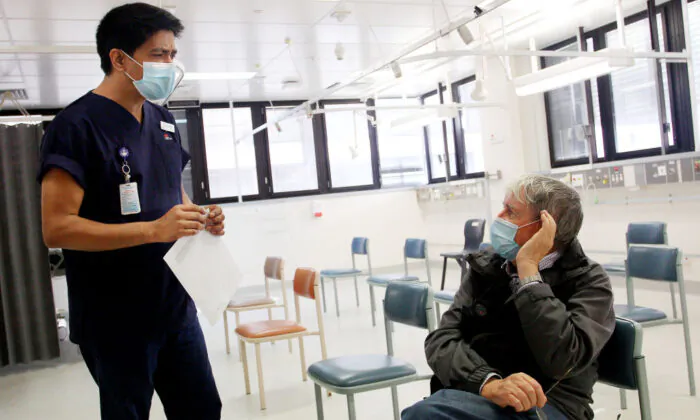 Registered Nurse Laxman Adhikari speaks with John Eberhardt in the clinical assessment room at St George Hospital in Sydney, Australia on May 15, 2020. (Maree Williams/Getty Images)