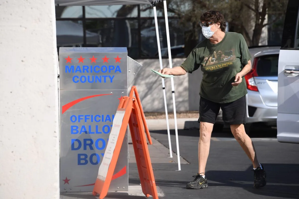 People deposit their mail-in ballots for the presidential election at a ballot collection box in Phoenix, Ariz., on Oct. 18, 2020. (Robyn Beck/AFP via Getty Images)