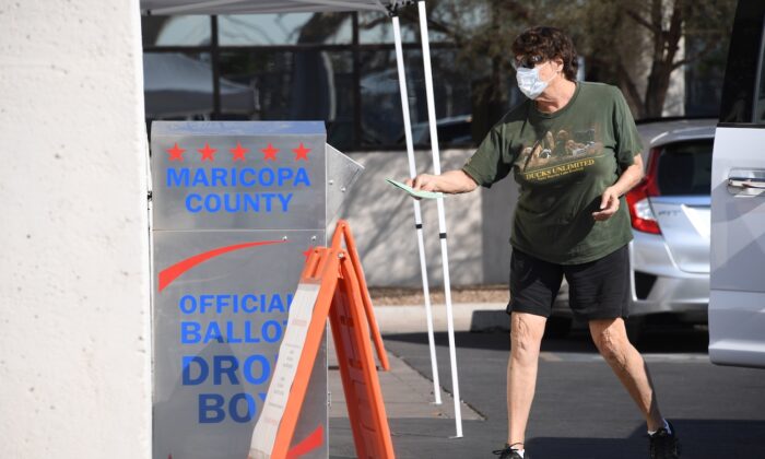 People deposit their mail-in ballots for the presidential election at a ballot collection box in Phoenix, Ariz., on Oct. 18, 2020. (Robyn Beck/AFP via Getty Images)