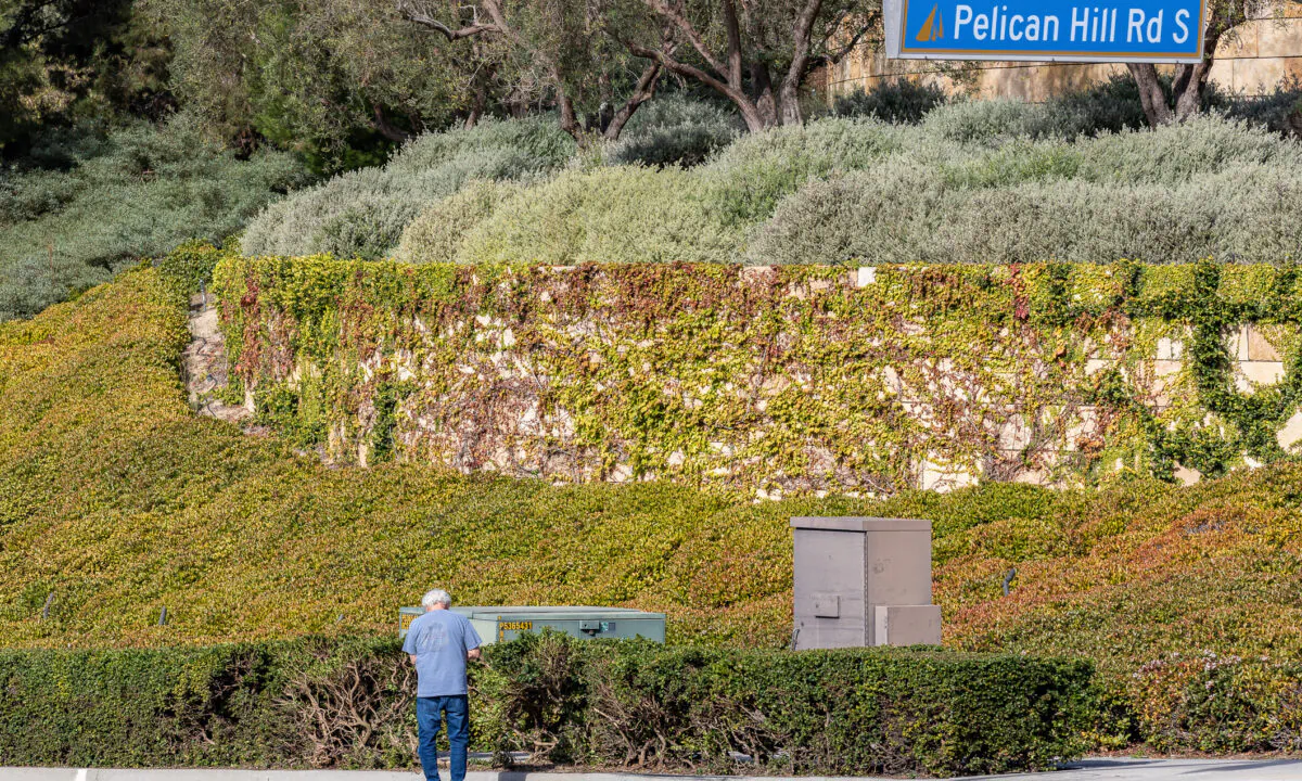 A man pays respects near the site of a crash that killed two parents and injured their three children in Newport Beach, Calif., on Dec. 9, 2020. (John Fredricks/The Epoch Times)