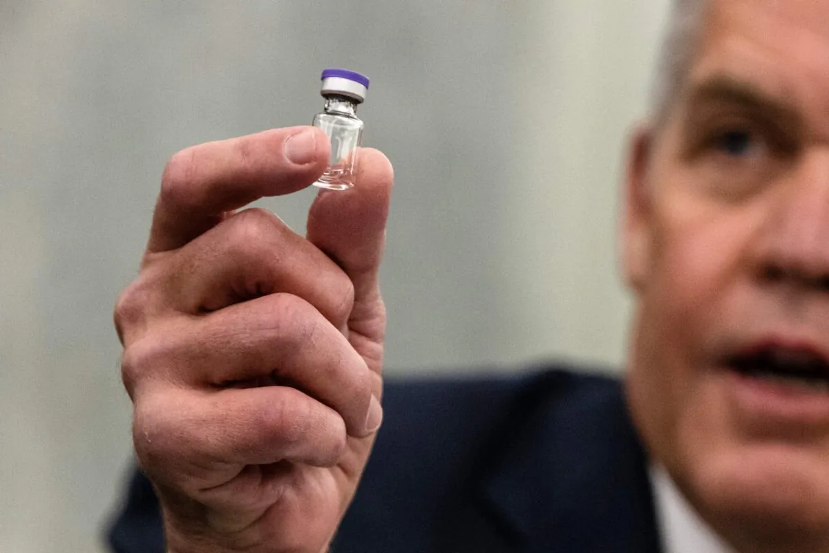 Wesley Wheeler holds up a sample of the vial that will be used to transport the Pfizer Covid-19 vaccine during a hearing in Washington on Dec. 10, 2020. (Samuel Corum/POOL/AFP via Getty Images)