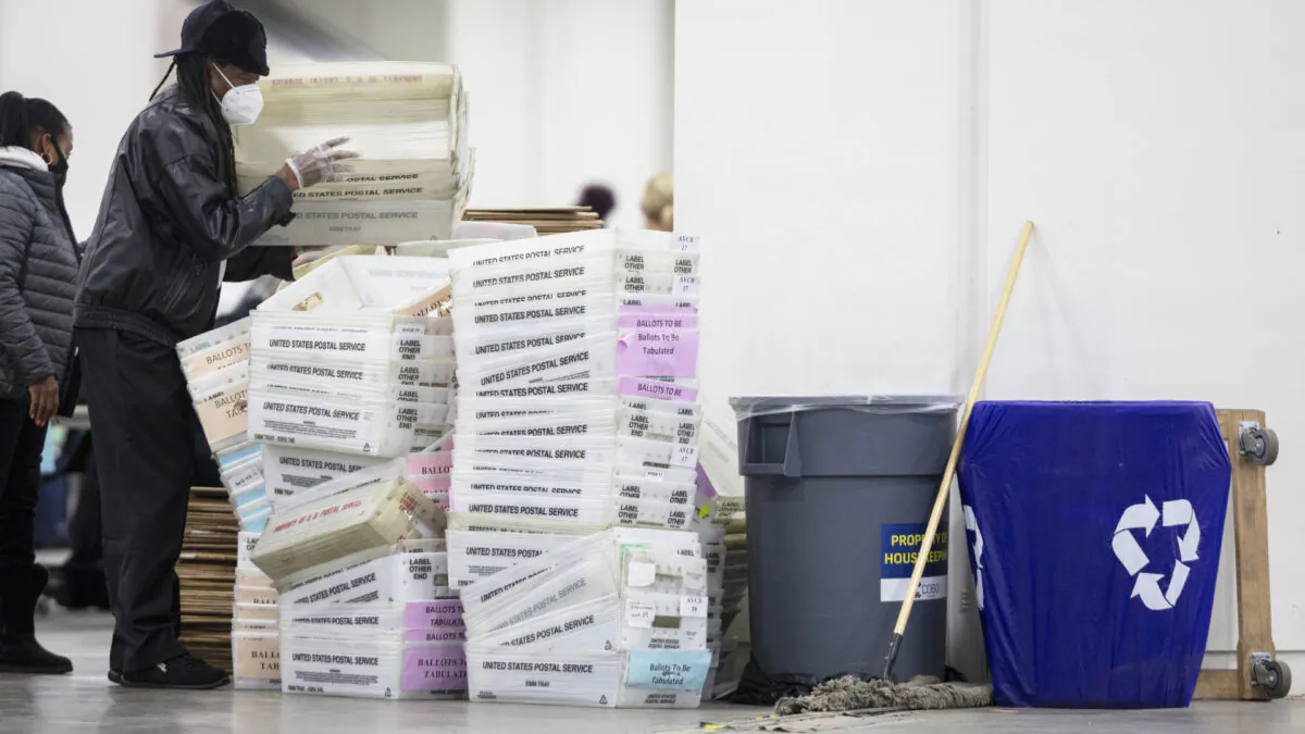A worker with the Detroit Department of Elections helps stack empty boxes used to organize absentee ballots after nearing the end of the absentee ballot count at the Central Counting Board in the TCF Center in Detroit, Mich. on Nov. 4, 2020. (Elaine Cromie/Getty Images)
