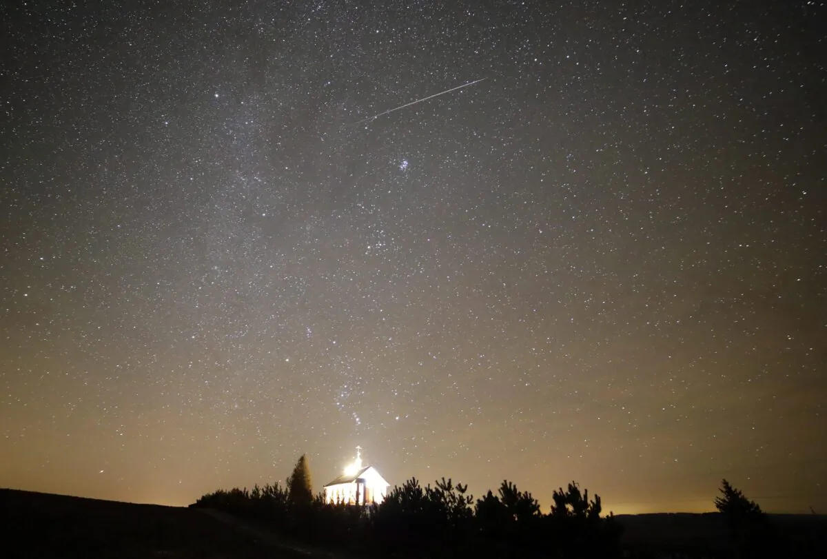 A meteor streaks across the sky during the annual Geminids meteor shower over an Orthodox church on the local cemetery near the village of Zagorie, some 69 miles west of capital Minsk, Belarus, on Dec. 13, 2017. (Sergei Grits/AP Photo)
