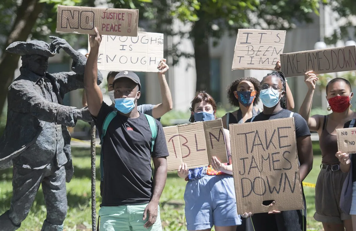 McGill University students protest next to the statue of founder James McGill on Aug. 1, 2020, calling on the university to take down the statue. (The Canadian Press/Graham Hughes)
