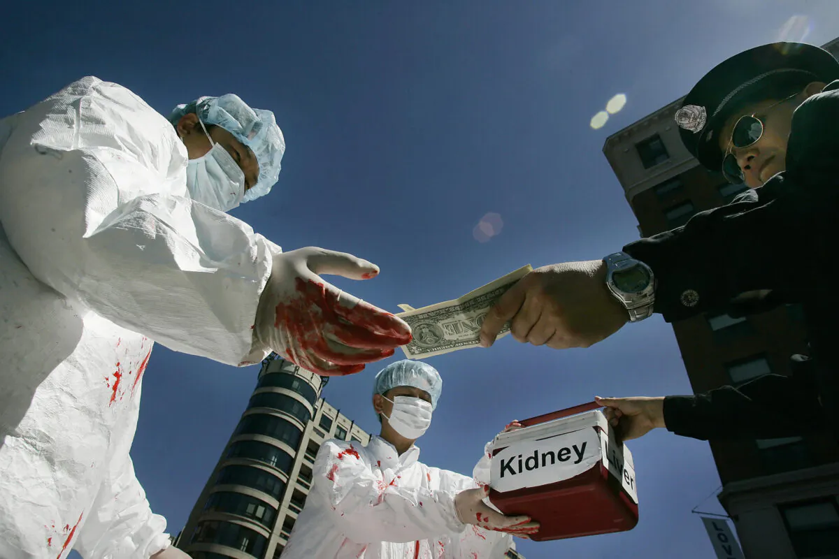 Falun Gong practitioners demonstrate an illegal act of paying for human organs, which happens in China, in Washington, D.C., on April 19, 2016. (JIM WATSON/AFP via Getty Images)