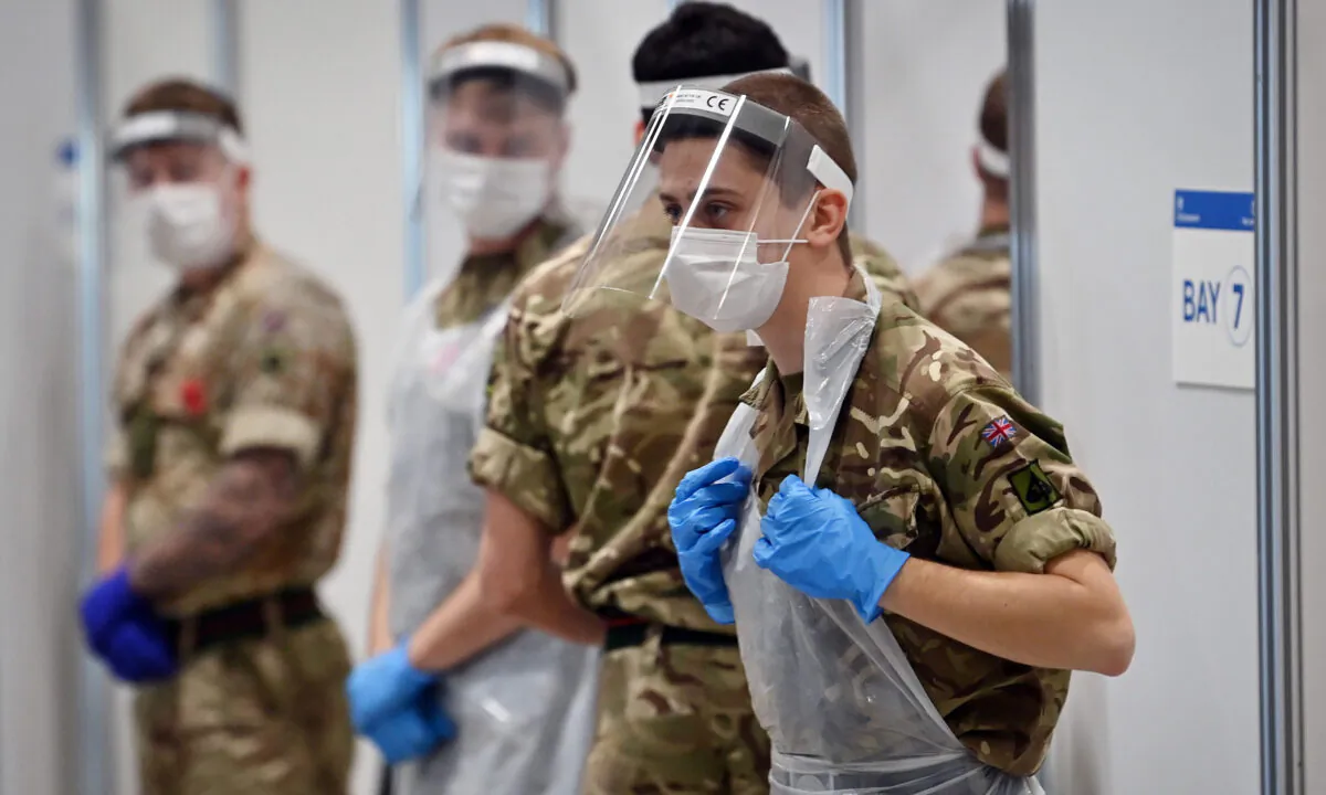 Soldiers wearing full PPE in the form of face shields, gloves, face masks and bibs wait to assist CCP virus testing at a rapid testing centre in the Liverpool exhibition centre in Liverpool, England, on Nov. 11, 2020. (Paul Ellis/AFP via Getty Images)