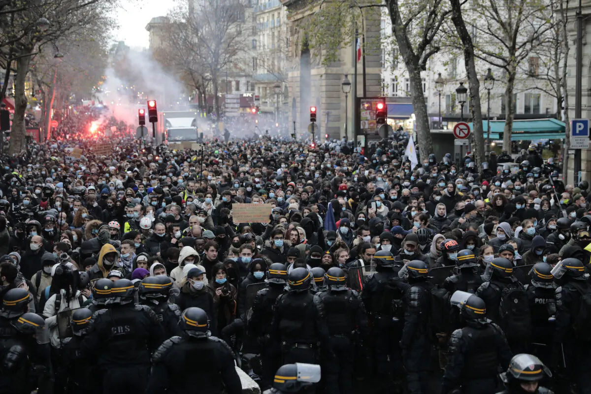 Demonstrators are blocked by police officers during a protest against a proposed bill in Paris, France, on Dec. 12, 2020. (Lewis Joly/AP Photo)