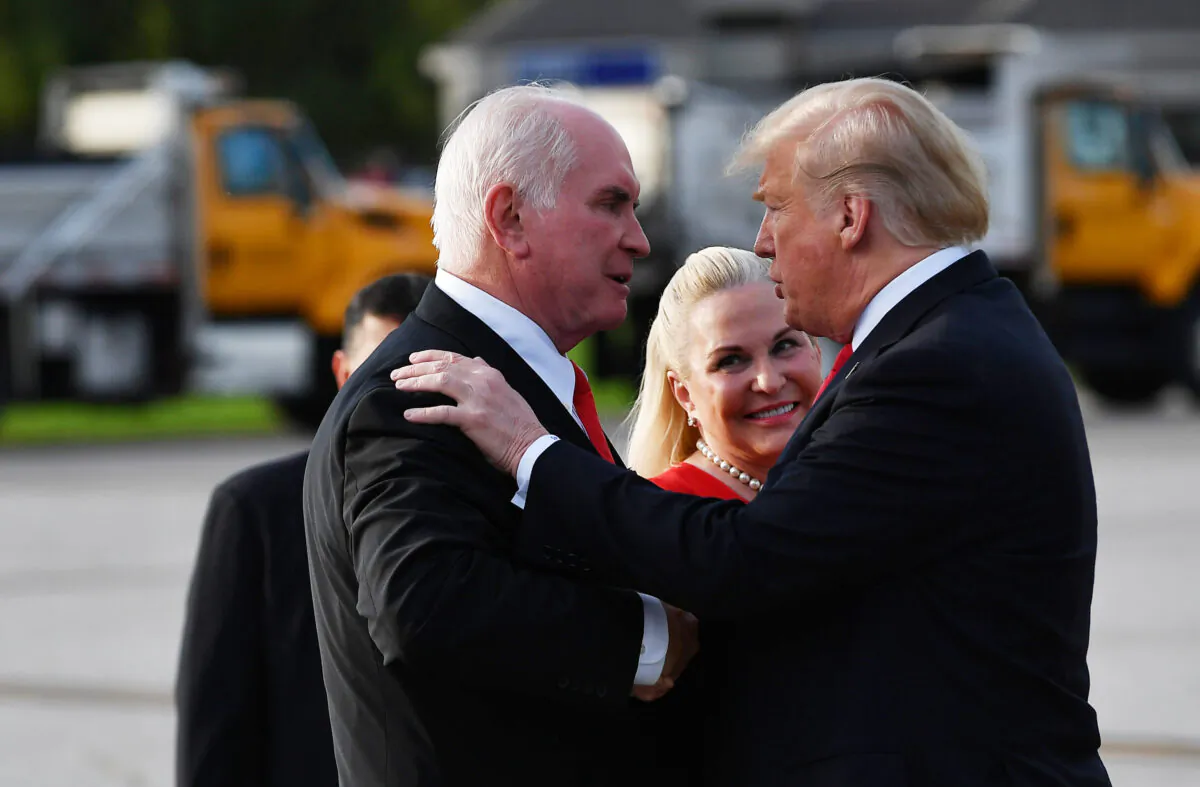 President Donald Trump, right, greets Rep. Mike Kelly (R-Pa.) and his wife Victoria upon arrival at Erie International Airport in Erie, Pa. on Oct. 10, 2018. (Mandel Ngan/AFP via Getty Images)