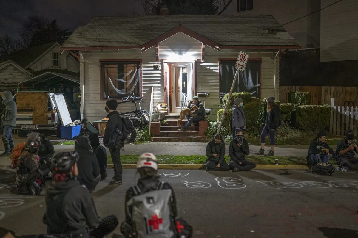 People gather outside a house where a family was set to be evicted, inside a so-called autonomous zone, in Portland, Ore., on Dec. 9, 2020. (Nathan Howard/Getty Images)
