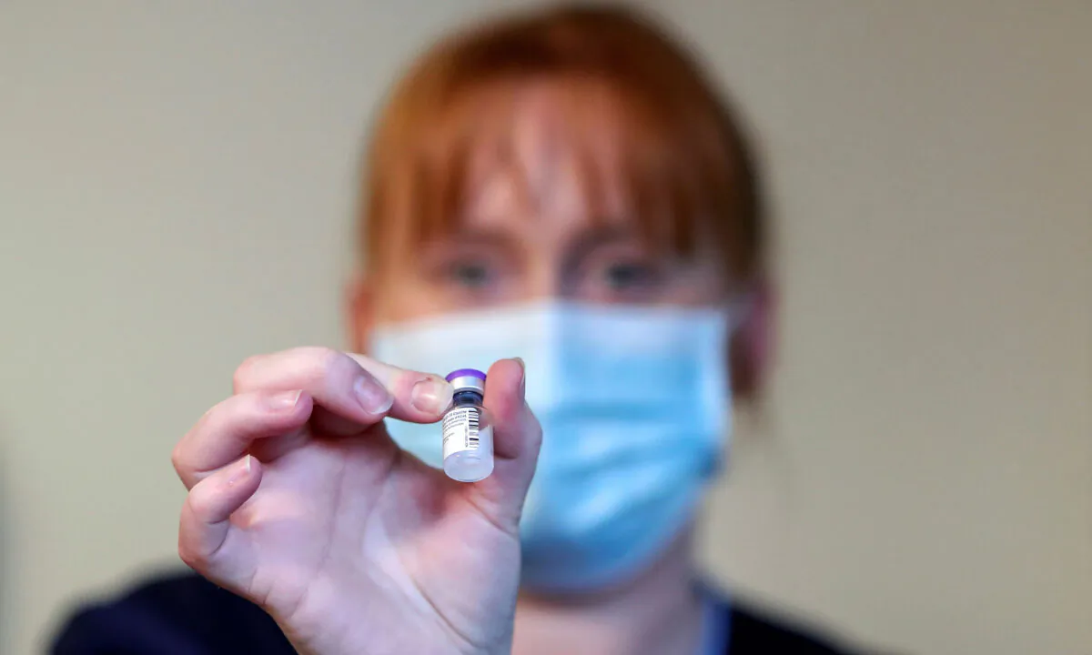 A member of staff holds a vial of the the Pfizer-BioNTech COVID-19 vaccine in Hamilton, western Scotland, on Dec. 14, 2020,  (Russell Cheyne/Pool/AFP via Getty Images)