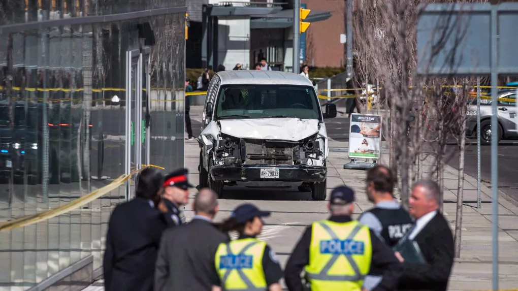 Police are seen near a damaged van in Toronto after a van mounted a sidewalk crashing into a number of pedestrians on April 23, 2018. (The Canadian Press/Aaron Vincent Elkaim)