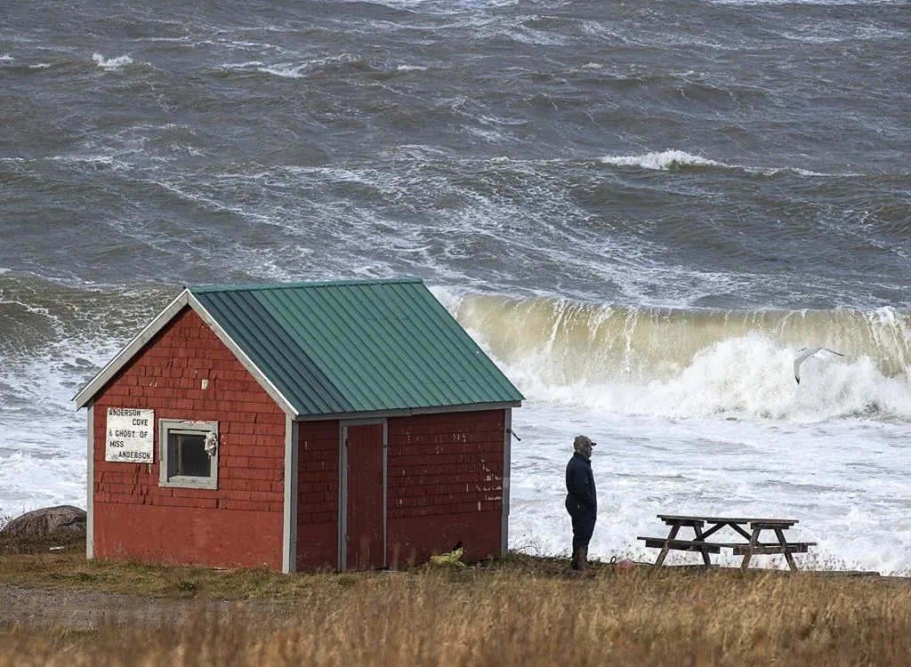 A man looks out onto the Bay of Fundy in Hillsburn, N.S. in an area where empty life-rafts from a scallop fishing vessel where reported on Tuesday, Dec. 15, 2020. Search and rescue aircraft, along with Canadian Coast Guard boats have been dispatched as well as ground search and rescue personnel. THE CANADIAN PRESS/Andrew Vaughan
