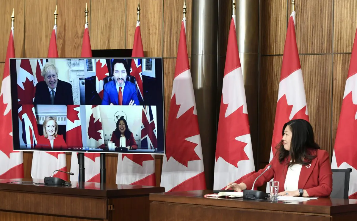 International Trade Minister Mary Ng watches footage from an earlier videoconference that she participated in with Prime Minister Justin Trudeau, U.K. Prime Minister Boris Johnson, and U.K. International Trade Secretary Liz Truss, during a news conference on the Canada-United Kingdom Trade Continuity Agreement in Ottawa on Nov. 21, 2020. (The Canadian Press/Justin Tang)