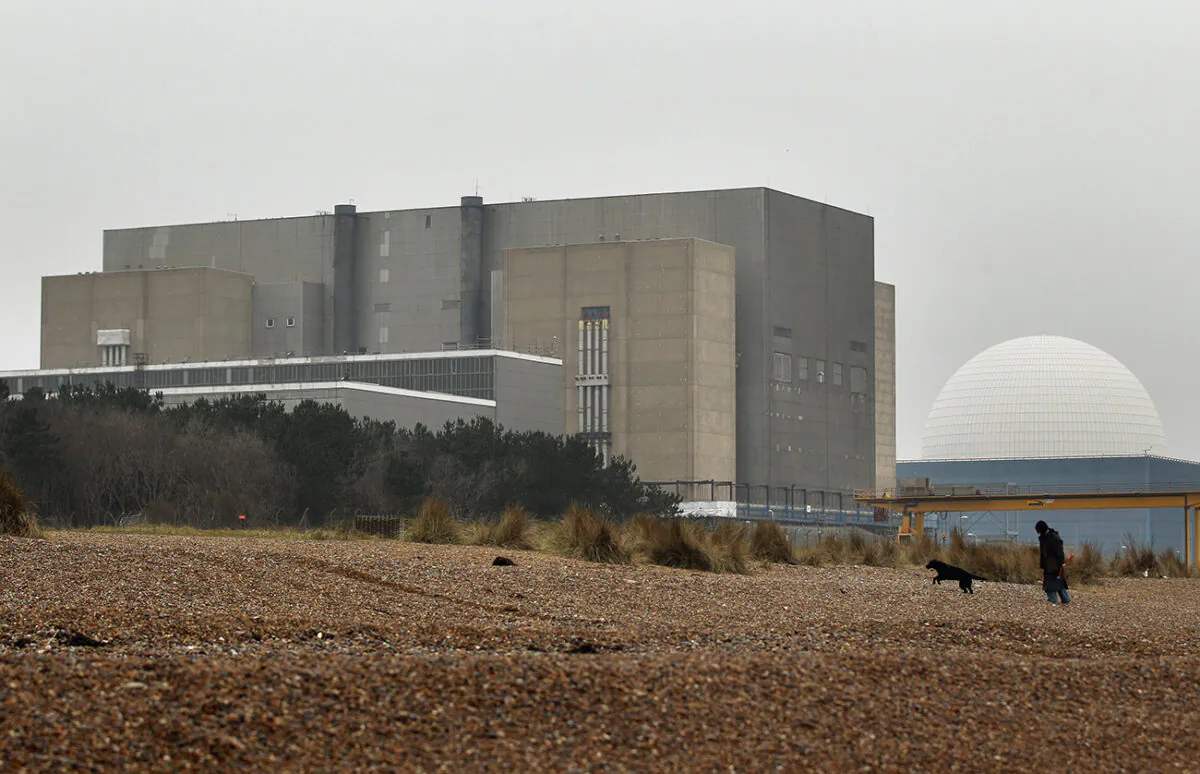 A woman walks her dog on the beach in front of Sizewell nuclear power station in Leiston, England, March 17, 2011. (Oli Scarff/Getty Images)