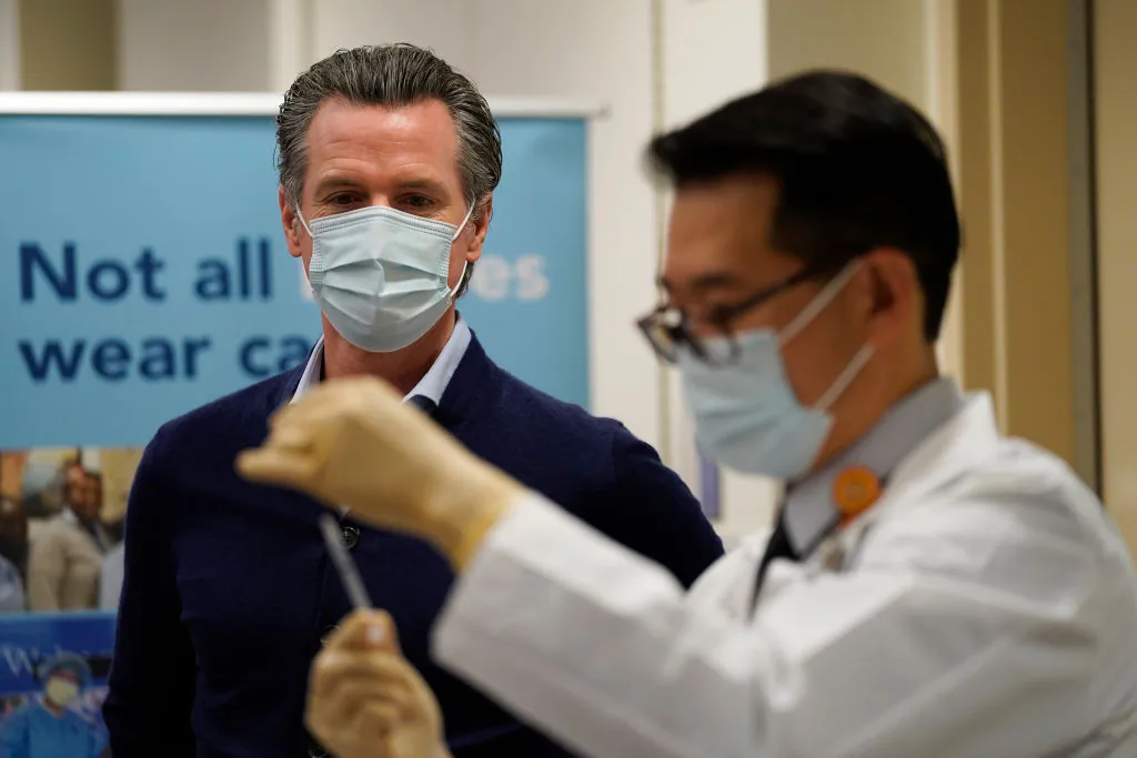Gov. Gavin Newsom watches as the Pfizer-BioNTech COVID-19 vaccine is prepared by Director of Inpatient Pharmacy David Cheng at Kaiser Permanente Los Angeles Medical Center in Los Angeles, Calif., on Dec. 14, 2020. (Jae C. Hong-Pool/Getty Images)