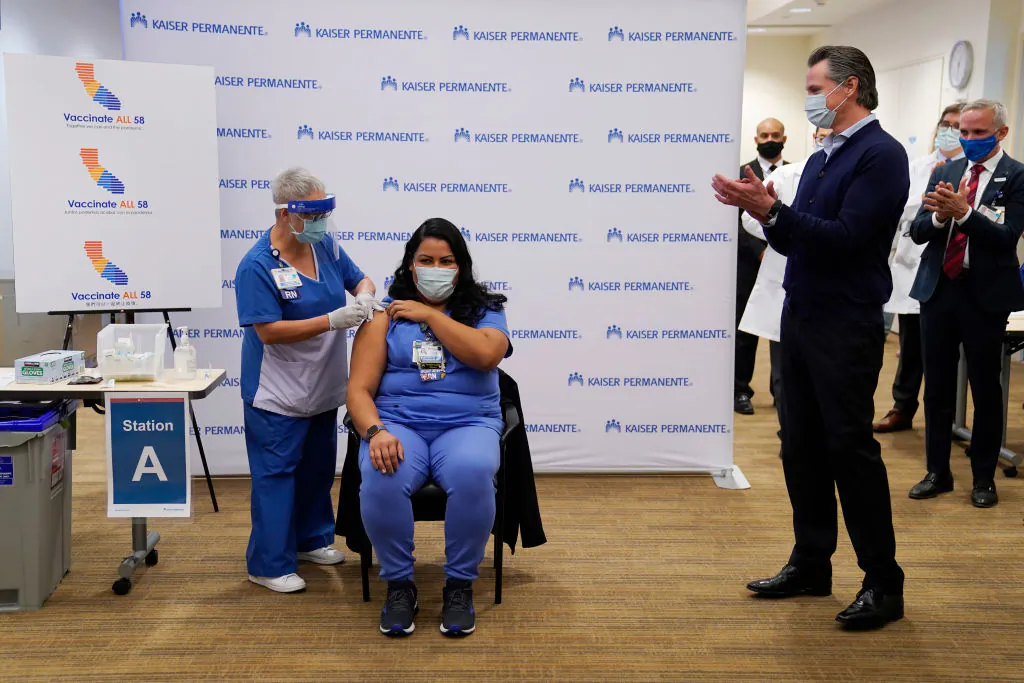 Gov. Gavin Newsom watches as ICU nurse Helen Cordova receives the Pfizer-BioNTech COVID-19 vaccine at Kaiser Permanente Los Angeles Medical Center in Los Angeles on Dec. 14, 2020. (Jae C. Hong-Pool/Getty Images)