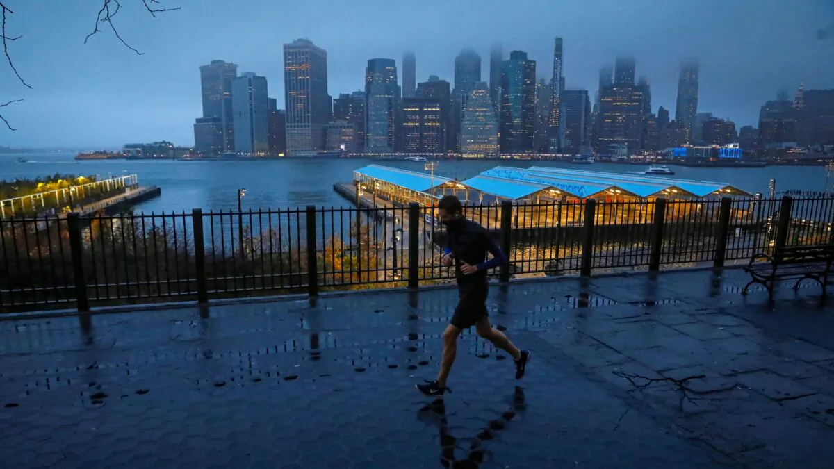 A man runs along the Brooklyn Heights Promenade as fog covers lower Manhattan in New York on Nov. 30, 2020. (Brendan McDermid/Reuters)