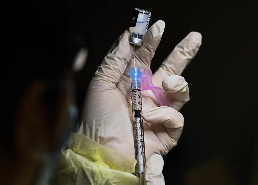 A health care worker prepares a syringe in this file photo. (The Canadian Press)