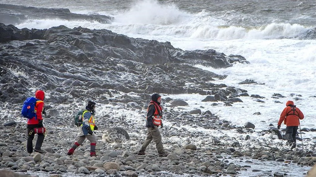 Members of a ground search and rescue team walk along the shore of the Bay of Fundy in Hillsburn, N.S. in an area where empty life-rafts from a scallop fishing vessel where reported on Dec. 15, 2020. (The Canadian Press/Andrew Vaughan)