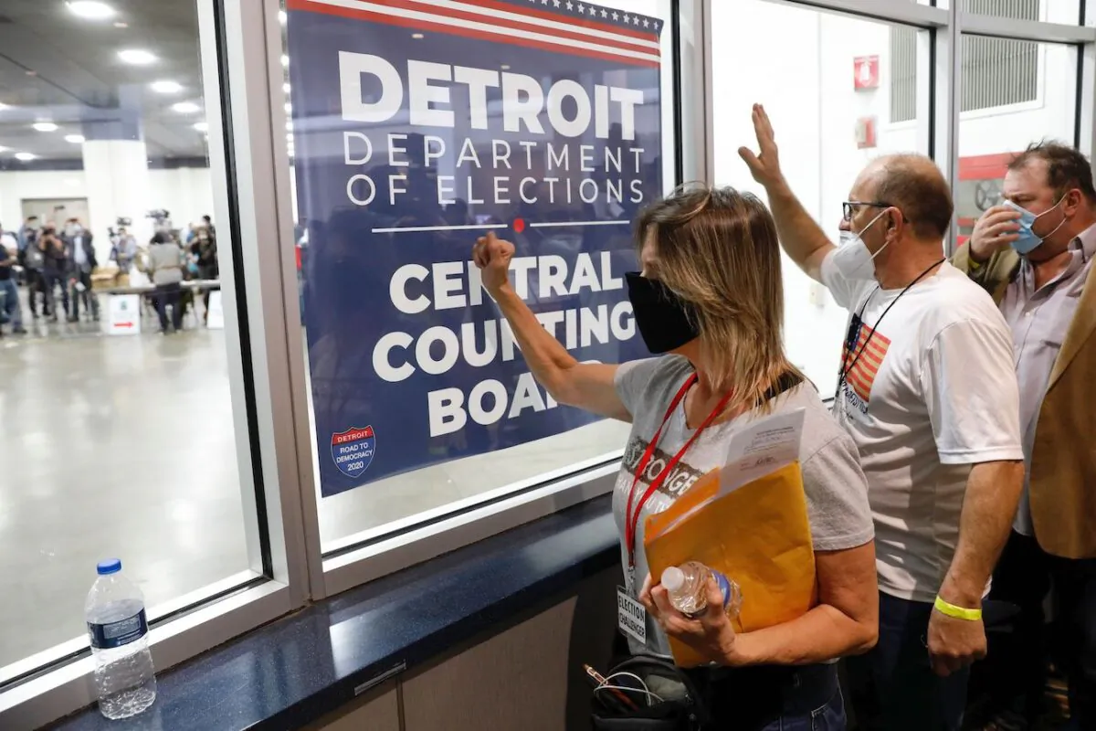 People stand outside the room where absentee ballots for the 2020 general election are being counted at TCF Center in Detroit, Michigan, on Nov. 4, 2020. (Jeff Kowalsky/AFP via Getty Images)