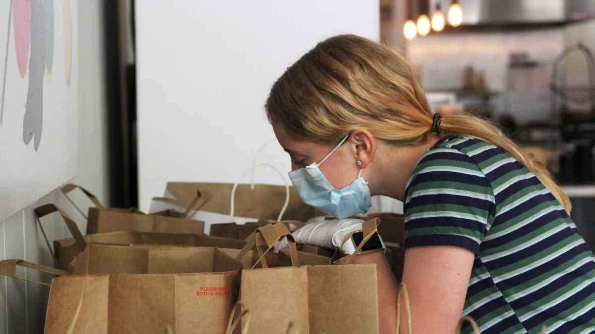 Makenna Hillyard, 13, checks a to-go order at Farley’s East in Oakland, Calif., on April 16, 2020. (Nathan Frandino/Reuters)