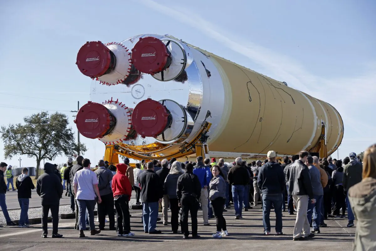 Employees and contractors watch as the core stage of NASA's Space Launch System rocket, that will be used for the Artemis 1 Mission, is moved to the Pegasus barge, at the NASA Michoud Assembly Facility where it was built, in New Orleans, La., on Jan. 8, 2020. (Gerald Herbert/AP Photo)