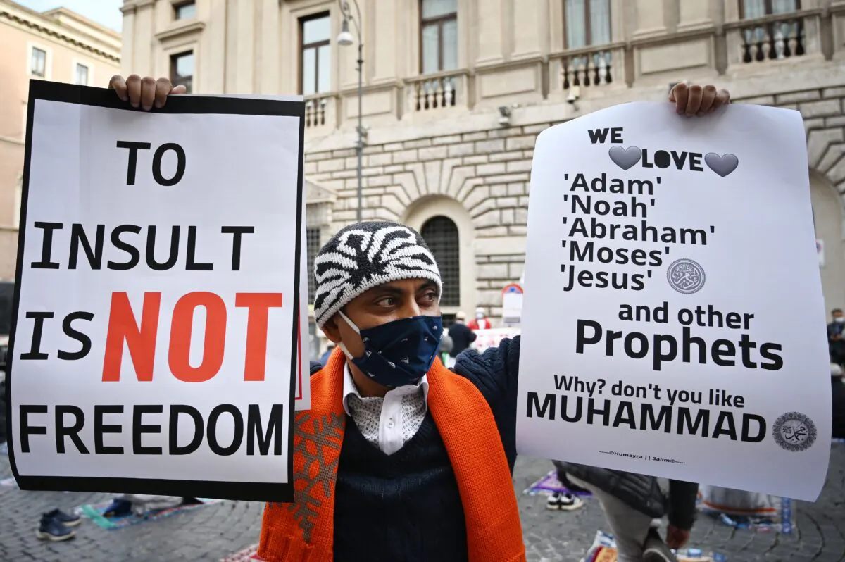 Muslims hold placards as they pray during a gathering on called against Islamophobia in central Rome, Italy, on Oct. 30, 2020. (Alberto Pizzoli/AFP via Getty Images)