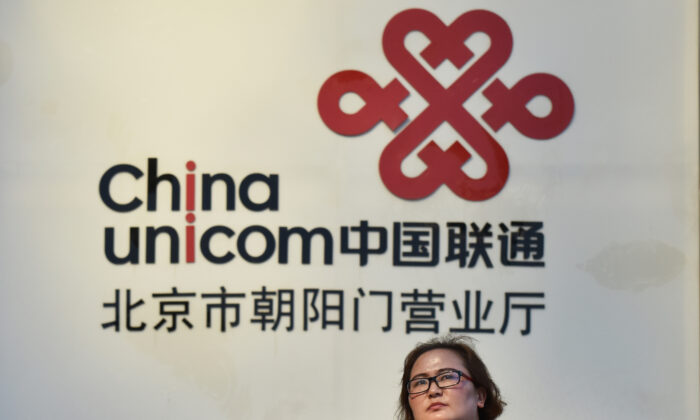 A woman walks past a China Unicom sign in Beijing on August 17, 2017. 
(Greg Baker/AFP via Getty Images)